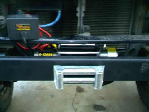1989 Ford Bronco - Close-up of a vehicle's front bumper and winch assembly, with visible wiring and a roller fairlead.