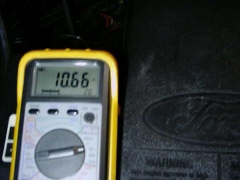 1984 Ford Bronco - A digital multimeter is shown next to a Ford emblem, likely indicating a vehicle part or diagnostic tool.