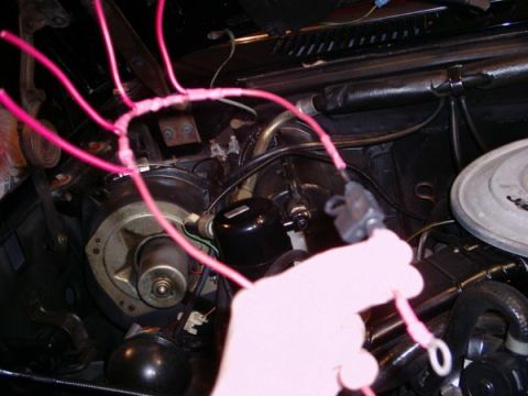 1984 Ford Bronco - A close-up view of wiring work being done in a vehicle's engine compartment.
