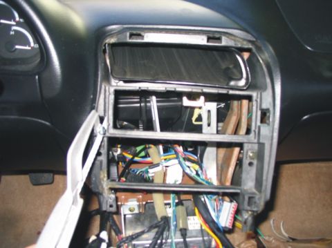 1993 Ford Probe - The central console of a car is disassembled, revealing a complex network of wires and electronic components.