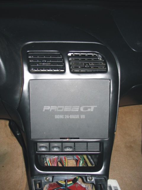 1993 Ford Probe - Interior center dash of a Ford Probe showing two black air vents above a removable storage panel embossed 'PROBE GT DOHC 24-VALVE V6'. Belo…