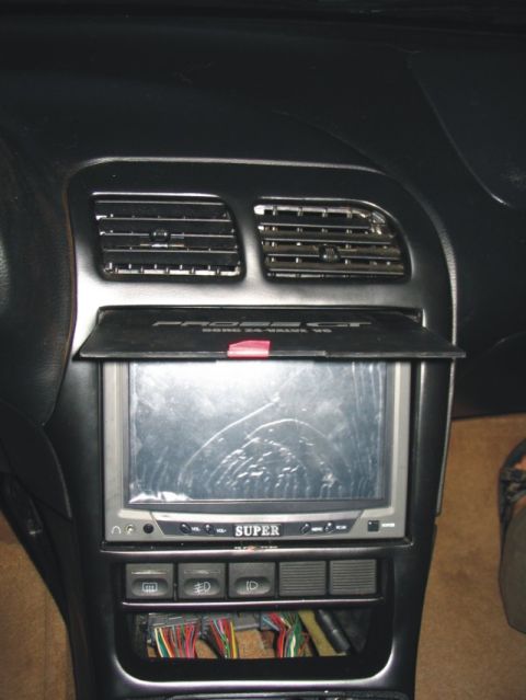 1993 Ford Probe - Interior center console of a Ford Probe showing the dashboard with dual air vents at top, a small aftermarket 'SUPER' brand screen/monitor…