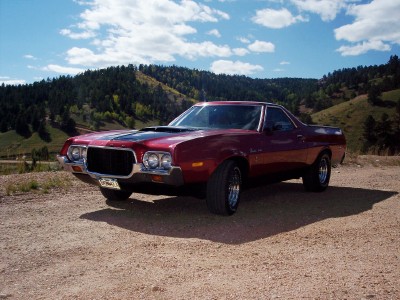 1972 Ford Ranchero - Maroon 1972 Ford Ranchero sits on a gravel road with a scenic backdrop of rolling hills.