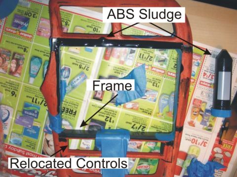 1993 Ford Probe - A DIY project showing a red plastic frame with black ABS sludge sealant applied around its edges, held together with blue painter's tape ov…