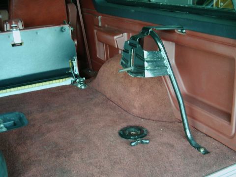 1984 Ford Bronco - Interior view of a vehicle showing a tire rack mount and brown carpet, with "SUPERMOTORS" visible.