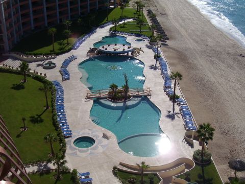 1991 Ford Bronco - A resort complex features multiple swimming pools and a sandy beach adjacent to the ocean.
