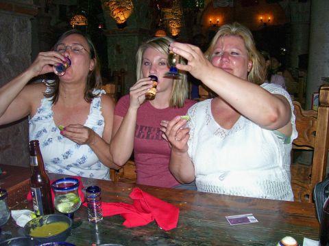 1991 Ford Bronco - Three women are shown taking shots of tequila at a table in what appears to be a restaurant.