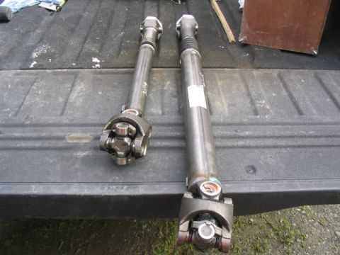 1978 Ford Bronco - Two driveshafts are shown laid out on a dark, textured surface, possibly a truck bed.