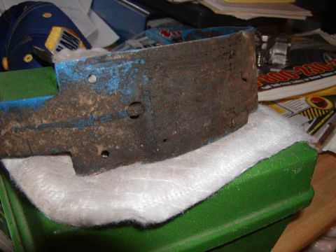 1978 Ford Bronco - A heavily rusted metal component sits on white padding, obscuring any identifying marks.
