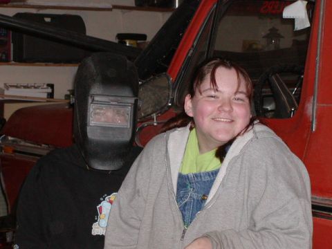 1978 Ford Bronco - Two people pose in front of a red vehicle, with some text visible on the window.