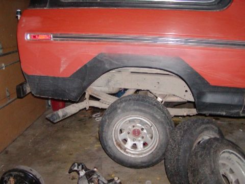 1978 Ford Bronco - Rear view of a red 1978 Ford Bronco showing the quarter panel, fender flare, and suspension components.