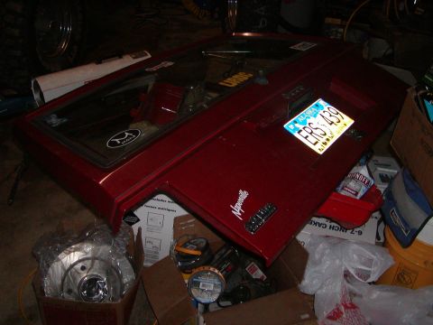 1978 Ford Bronco - Red tailgate with Alaska license plate ERS 439 and "Naperville" badge is stored indoors.