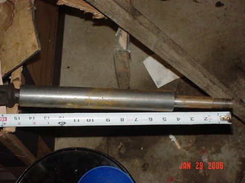 1978 Ford Bronco - A metal shaft with a threaded end is shown with a measuring tape indicating its length.