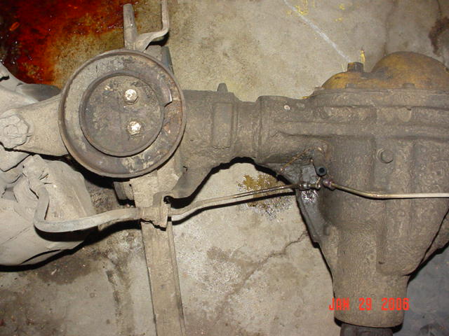 close-up of a dirty rear axle assembly with brake lines