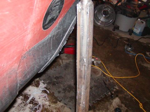 1978 Ford Bronco - A close-up view of a vehicle's body panel and a metal pole, with garage items in the background.