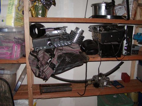 1978 Ford Bronco - Shelving unit with various items including electronics and car components.