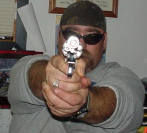1978 Ford Bronco - A man points a handgun forward, his face obscured by sunglasses and a bandana.