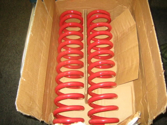 two red coil springs in a cardboard box