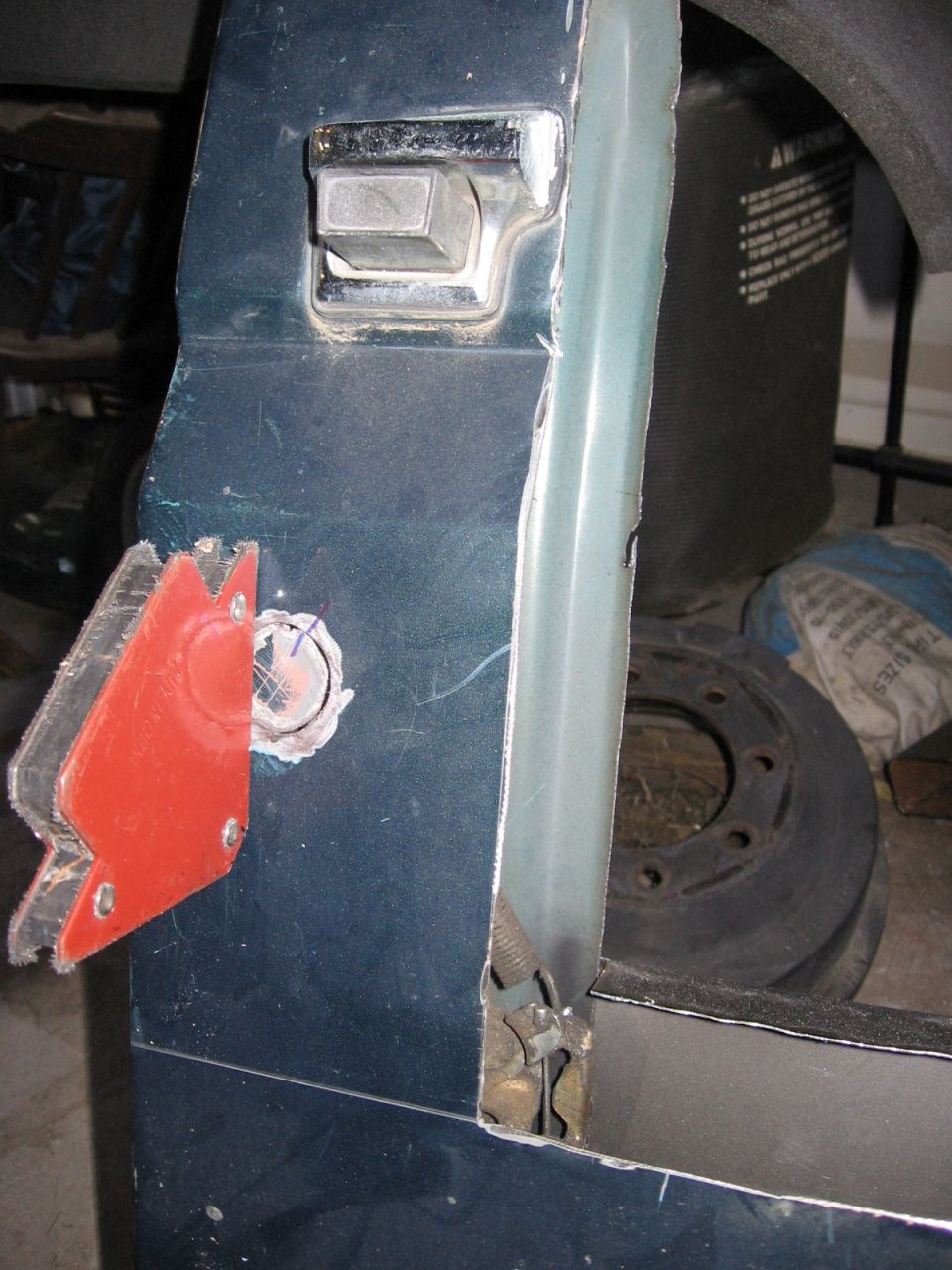 Dark blue body panel with chrome bezel and red welding magnet clamped on