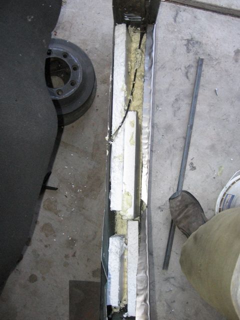 1994 Ford Bronco - The interior of a vehicle door panel is exposed, showing insulation and wiring components.