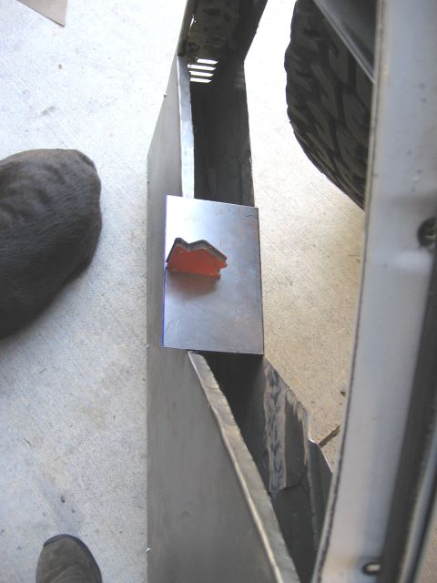 1994 Ford Bronco - A metal bracket with an orange reflector is mounted on a vehicle part.