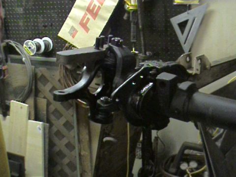 1985 Ford Bronco - A close-up view of a vehicle's suspension component, likely part of an axle, in a workshop environment.