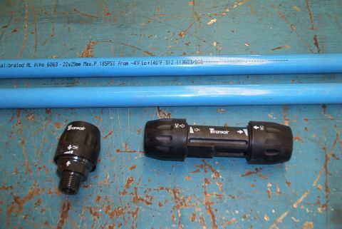 1983 Ford Bronco - Two Transair pneumatic fittings and blue pipes are laid out on a workbench. The pipes have specifications printed on them.