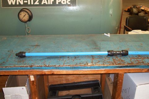 1983 Ford Bronco - A gauge is mounted on a large air compressor tank behind a blue pipe on a workbench.