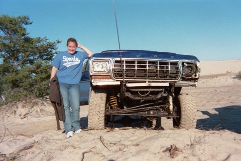 1979 Ford Bronco - A lifted 1979 Ford Bronco parked in a sandy landscape with a person standing beside it.