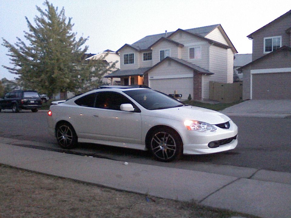 White Acura RSX parked on suburban street, another SUV in background