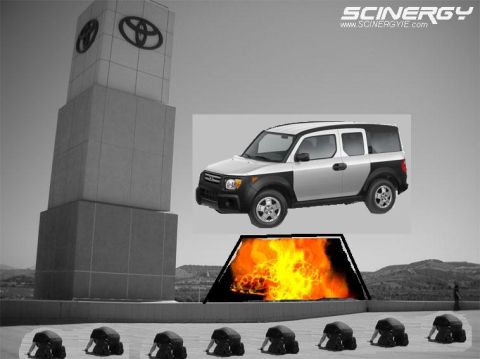 1993 Ford Taurus - A silver and black SUV is positioned in front of a large monument with Toyota logos, with a fiery display beneath it.