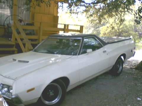 1972 Ford Ranchero - This 1972 Ford Ranchero is parked in a shaded area next to a building with a wooden staircase.
