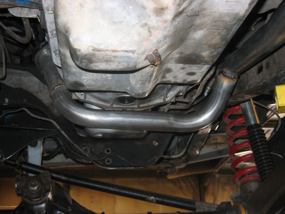 Undercarriage view showing exhaust pipe, transmission pan, red coil spring and shock