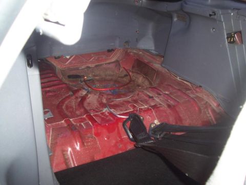 1995 Ford Probe - The interior of a car's trunk is shown, revealing the bare metal floor and some electrical wiring.
