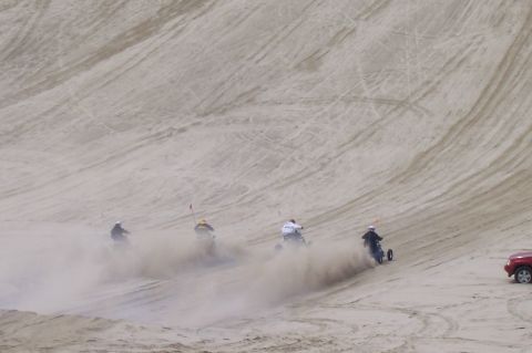 1994 Ford F-150 - Riders on three-wheeled vehicles navigate sandy terrain, with a red SUV visible on the side.