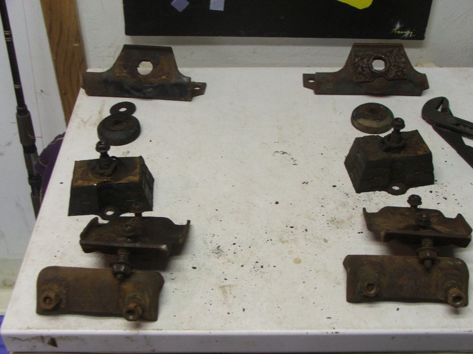Rusted metal brackets and components on a white surface