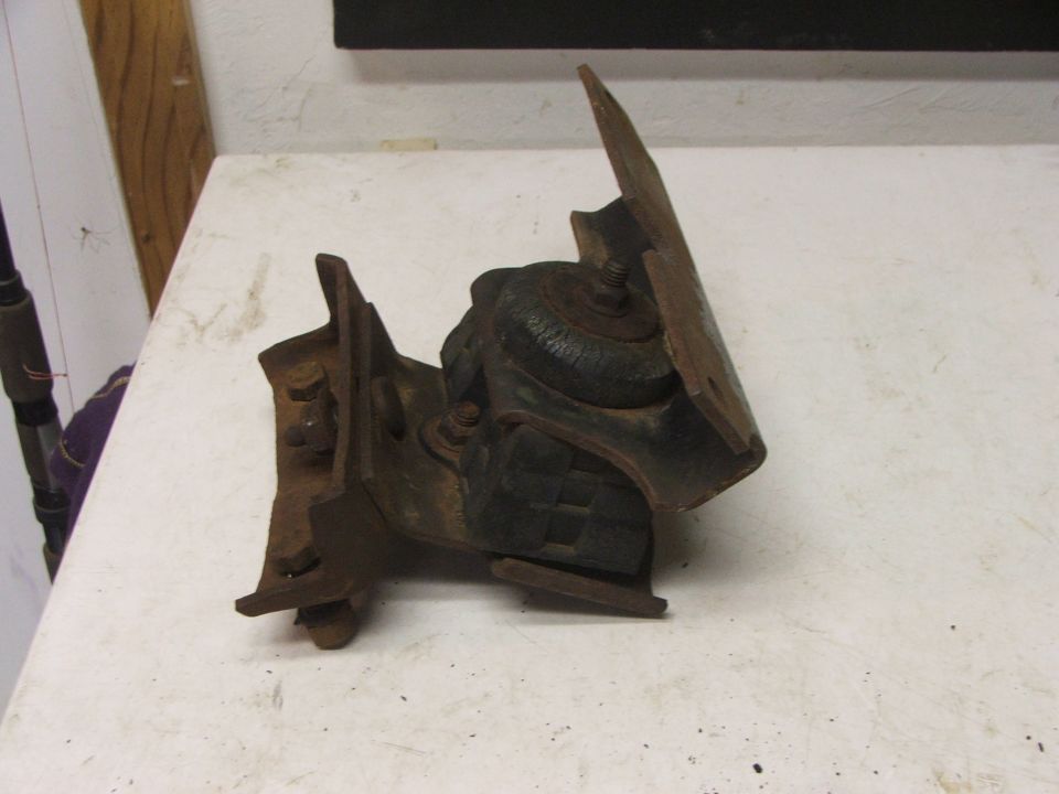 Rusty engine mount bracket with rubber insulator