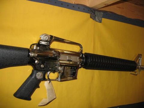 1994 Ford Bronco - Chrome AR-15 style rifle with "UNITED STATES ARMY" engraving is shown against a yellow background.