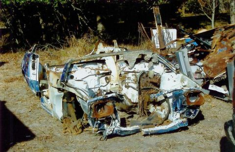 1997 Jeep TJ - This heavily damaged vehicle chassis is in a state of disrepair, with its front end exposed and rusted components visible.