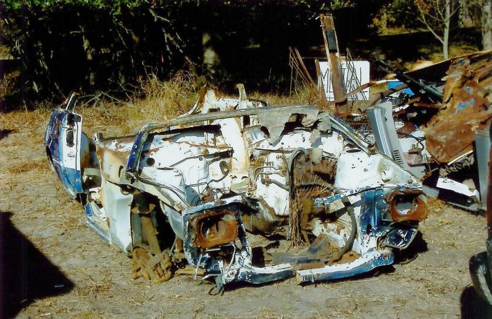 Wrecked vehicle chassis, front view, white and blue