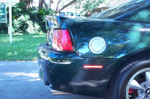 2001 Ford Mustang - The rear of a dark green coupe is shown, a spoiler and a fuel cap.