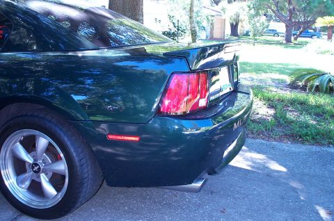 2001 Ford Mustang - Rear view of a dark green 2001 Ford Mustang, showing its distinctive taillight and spoiler.