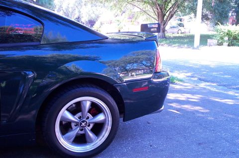 2001 Ford Mustang - Rear view of a dark blue 2001 Ford Mustang, showing its distinctive body lines and alloy wheel.