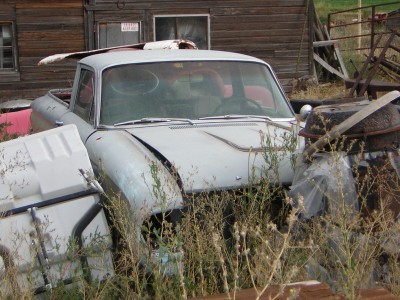 1972 Ford Ranchero - This weathered Ford Ranchero is surrounded by overgrown weeds and debris, suggesting it has been abandoned for some time.