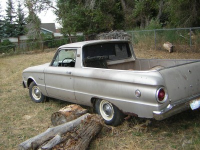 1972 Ford Ranchero - This vintage Ford Falcon Ranchero pickup truck is seen parked in a yard with trees and a fence in the background.