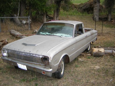 1972 Ford Ranchero - This 1960 Ford Ranchero pickup truck shows significant damage to its front end and is parked in an outdoor, grassy area.