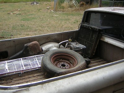 1972 Ford Ranchero - The bed of a 1972 Ford Ranchero is filled with a spare tire, radiator, and various other automotive parts.
