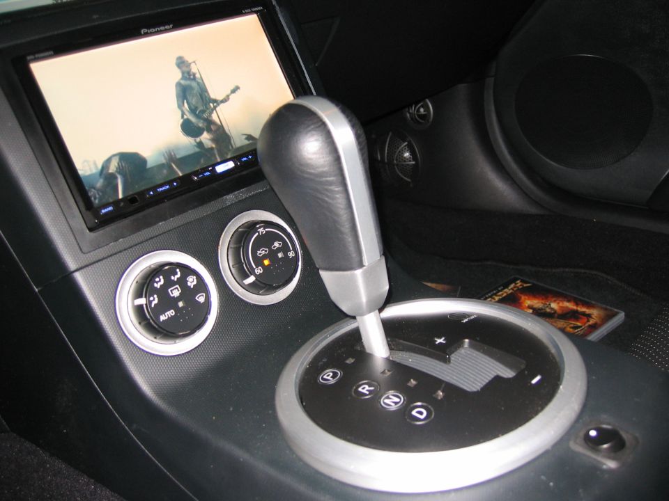 350Z center console with Pioneer touchscreen playing video, HVAC dials, and automatic shifter