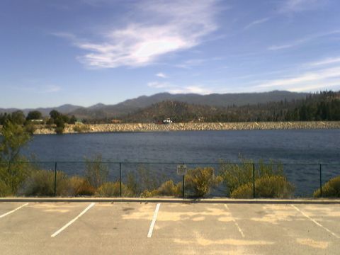 1972 Ford Ranchero - A scenic view of a calm lake bordered by land, with mountains visible in the distance under a bright sky.