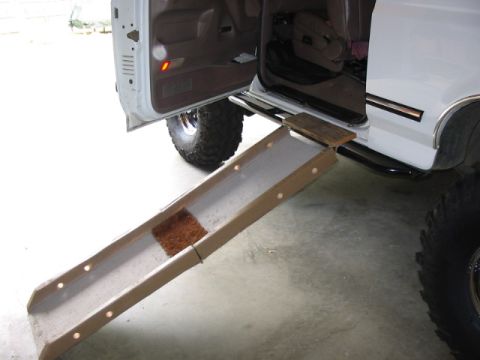 1995 Ford Bronco - A doggy ramp is positioned for access into the rear of a white vehicle.
